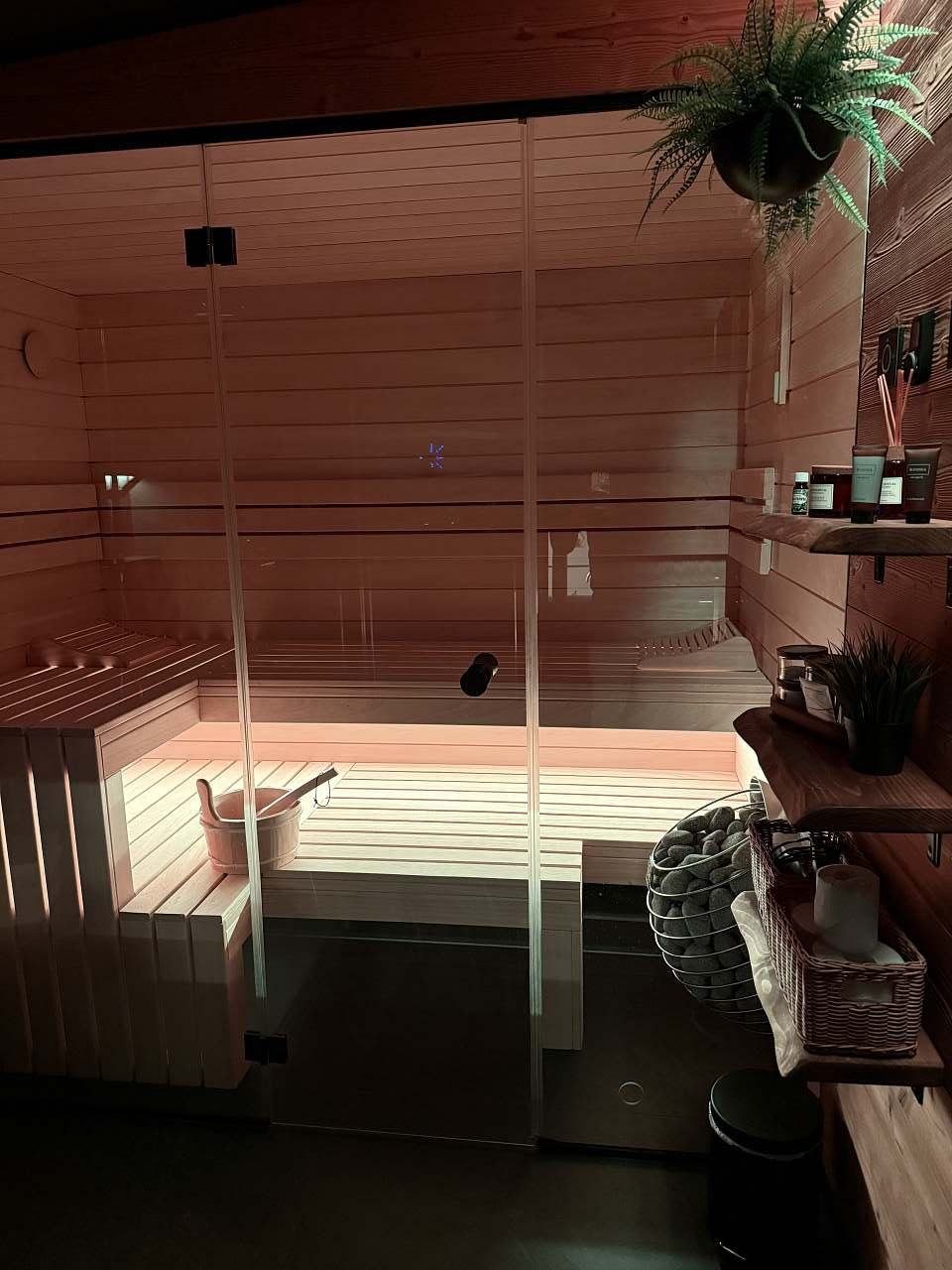 Prosklená sauna večer, teplé světlo na lavicích